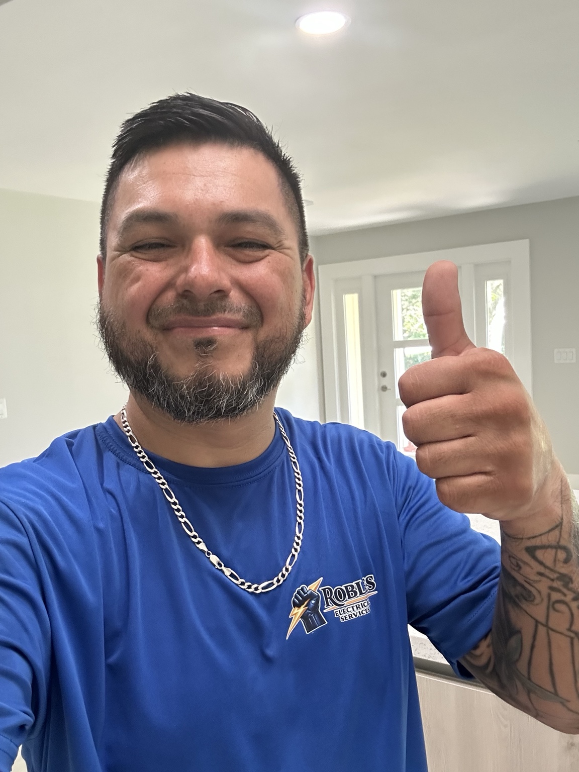 Armando Robles, owner of Robles Electrical Services, wearing his company shirt